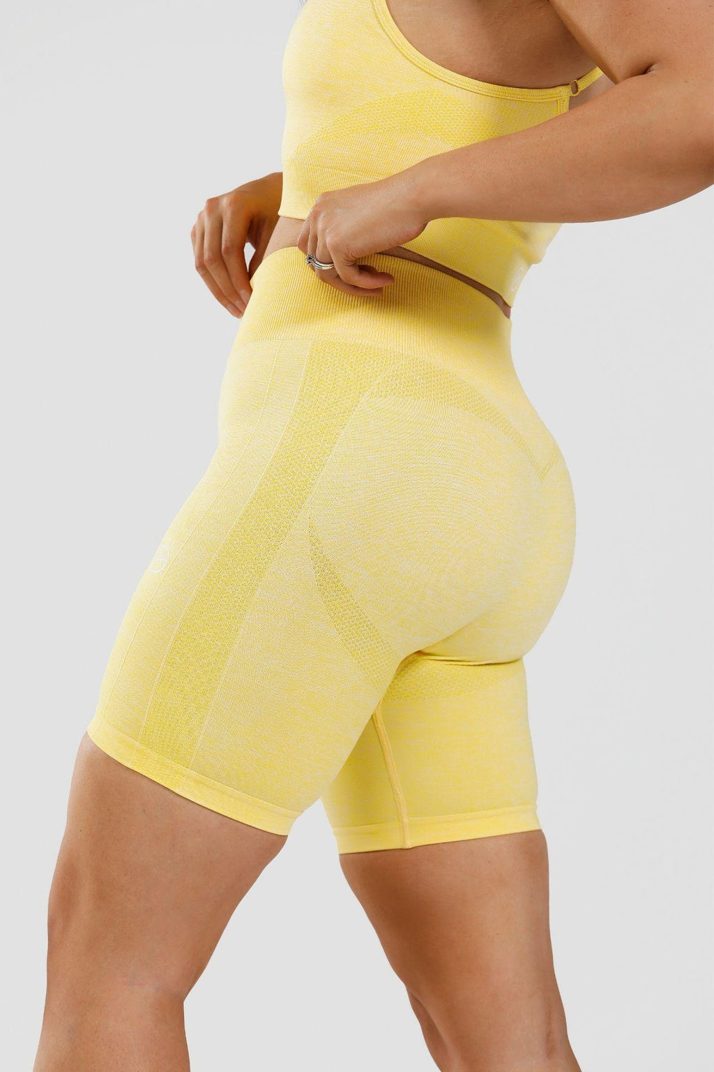 Close up side view of girl wearing yellow calypso seamless shorts