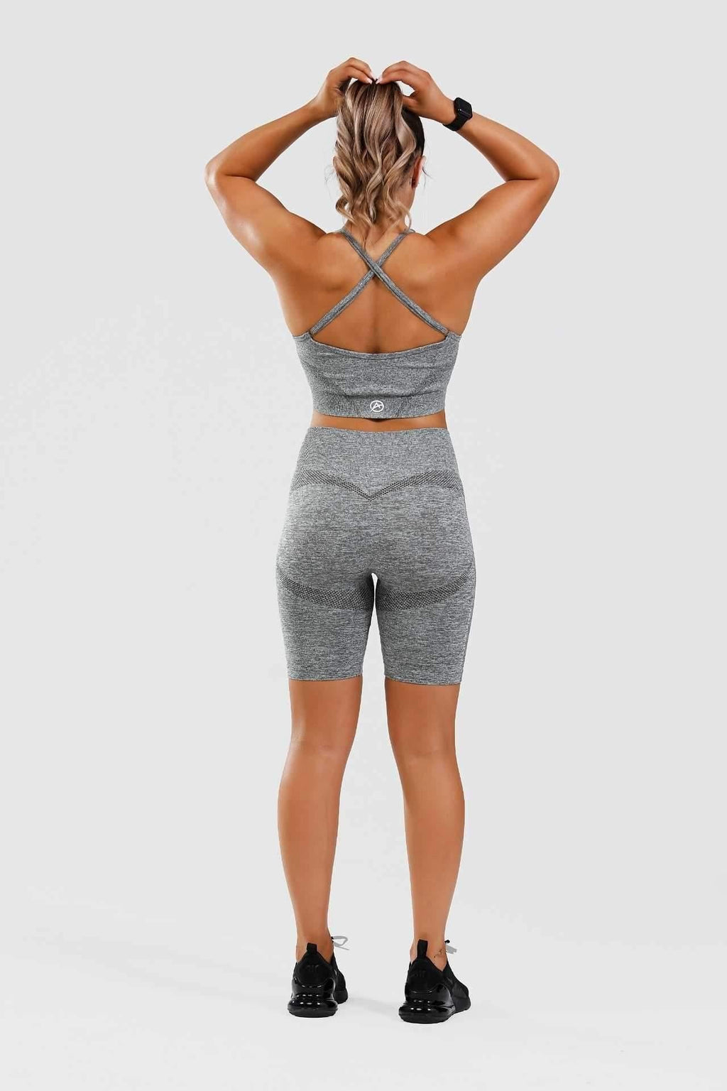 Girl holding hair up wearing grey calypso seamless set