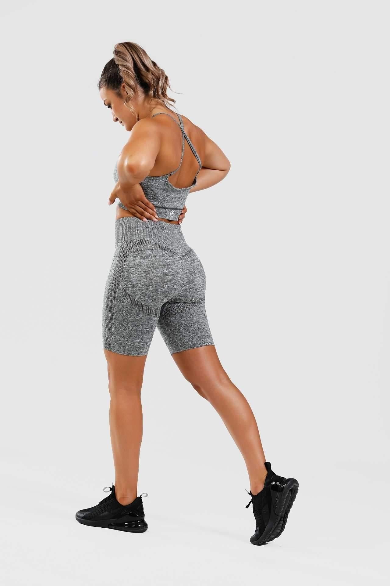 Girl posing hands on hips wearing grey calypso seamless set from behind