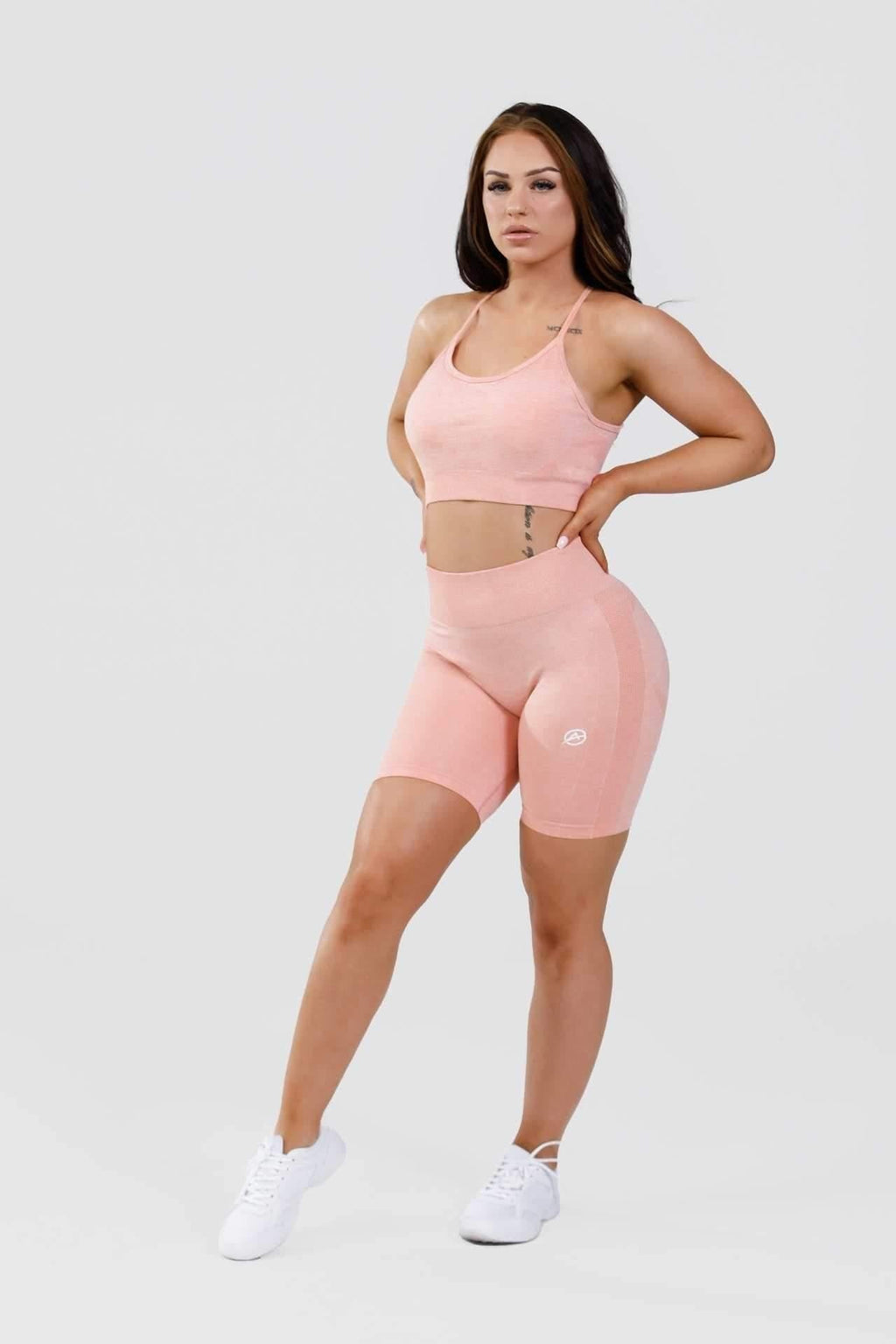 Girl hands on hips wearing calypso seamless set in pink marl front