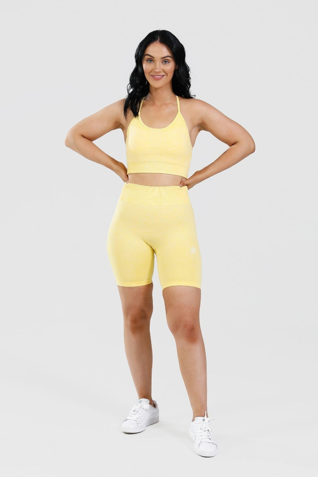 Girl hands on hips wearing calypso seamless set in yellow 