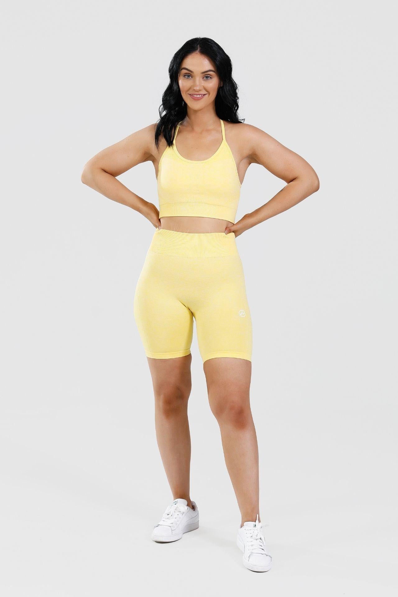 Girl hands on hips wearing calypso seamless set in yellow 
