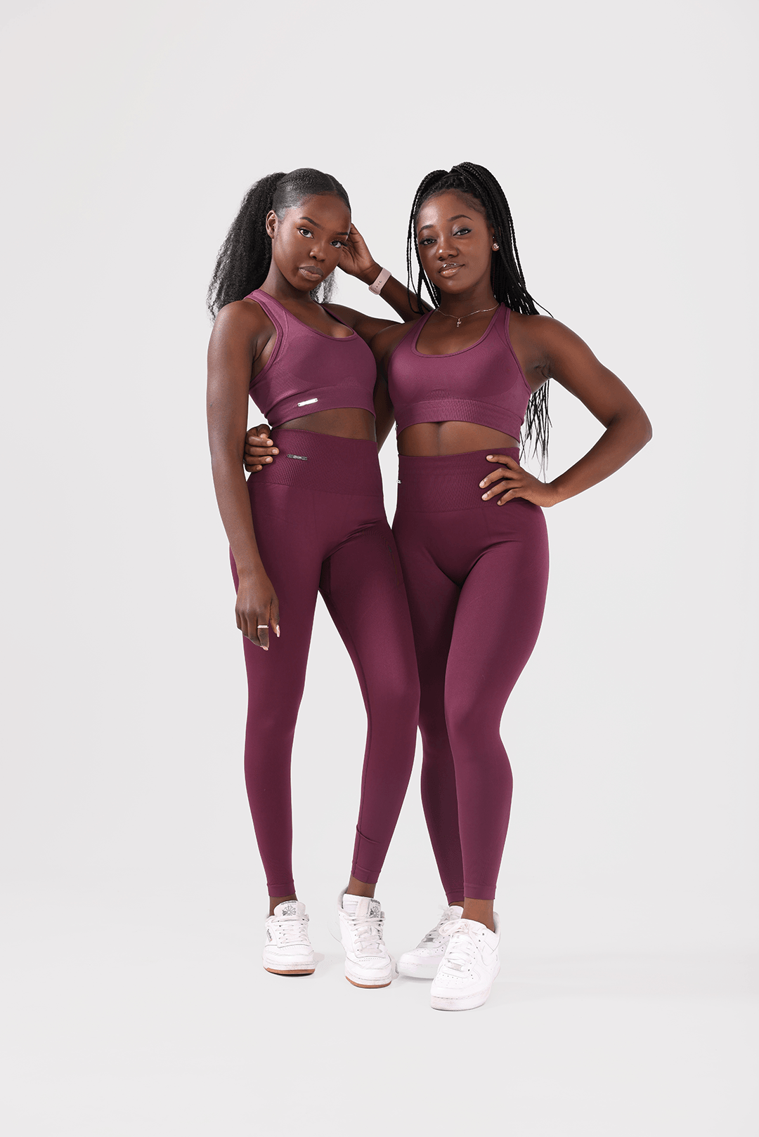 girls standing together both wearing invictus seamless set in plum purple 