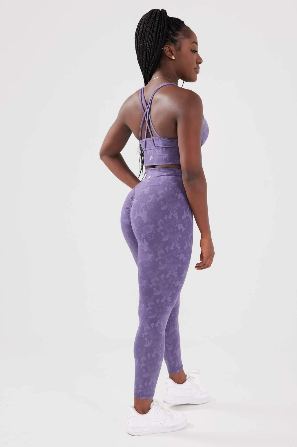 Girl posing hand on hip wearing legacy scrunch bum set in purple back