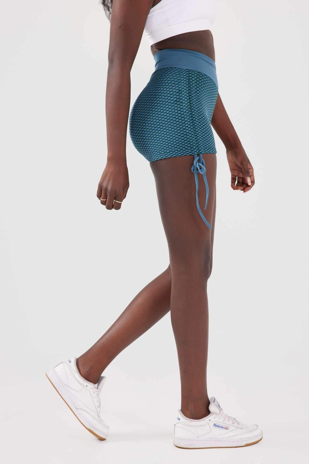 Side view girl wearing blue luna scrunch bum shorts