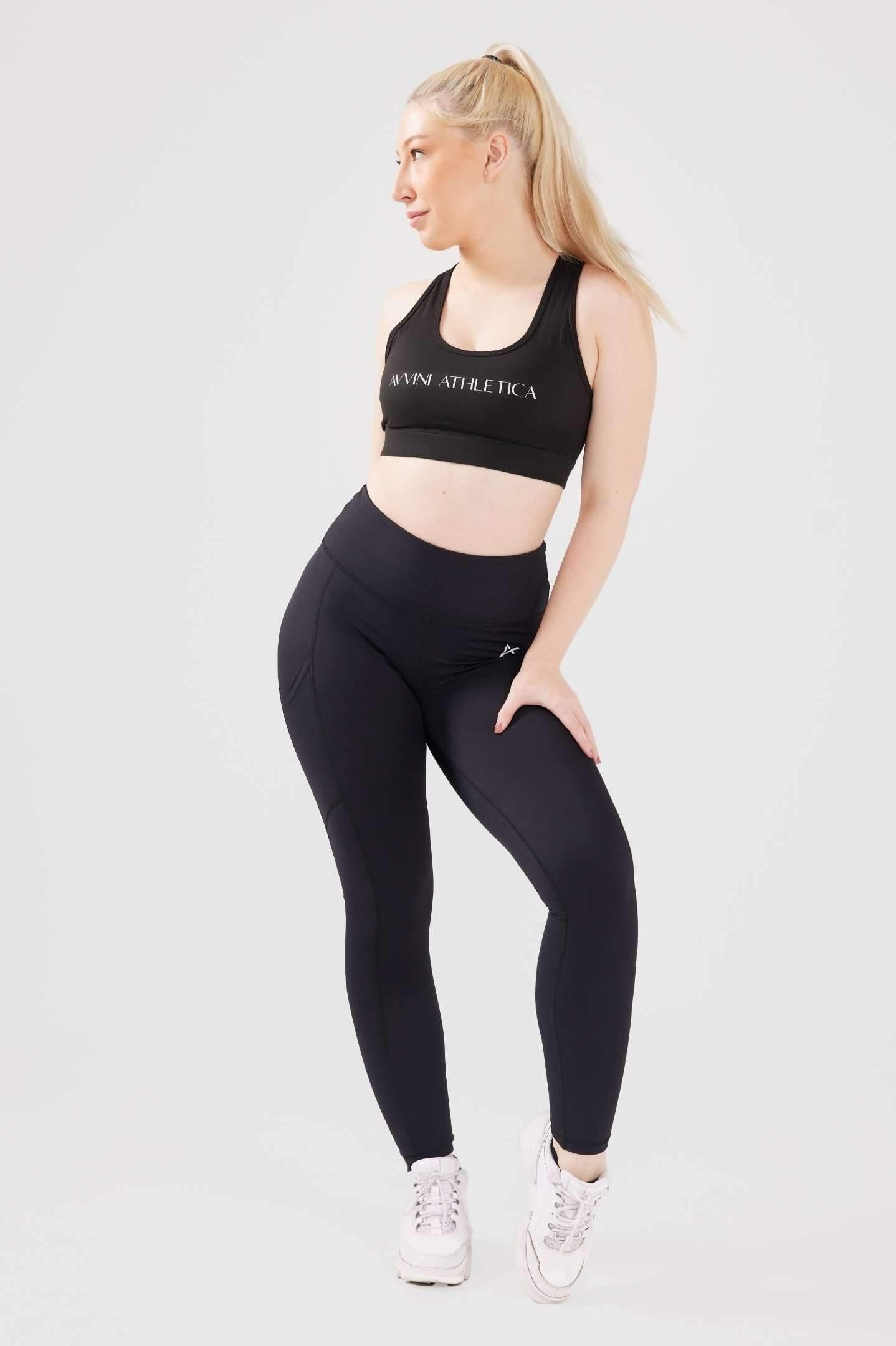 Girl looking to the side, posing hand on thigh, wearing black luxe pocket leggings 