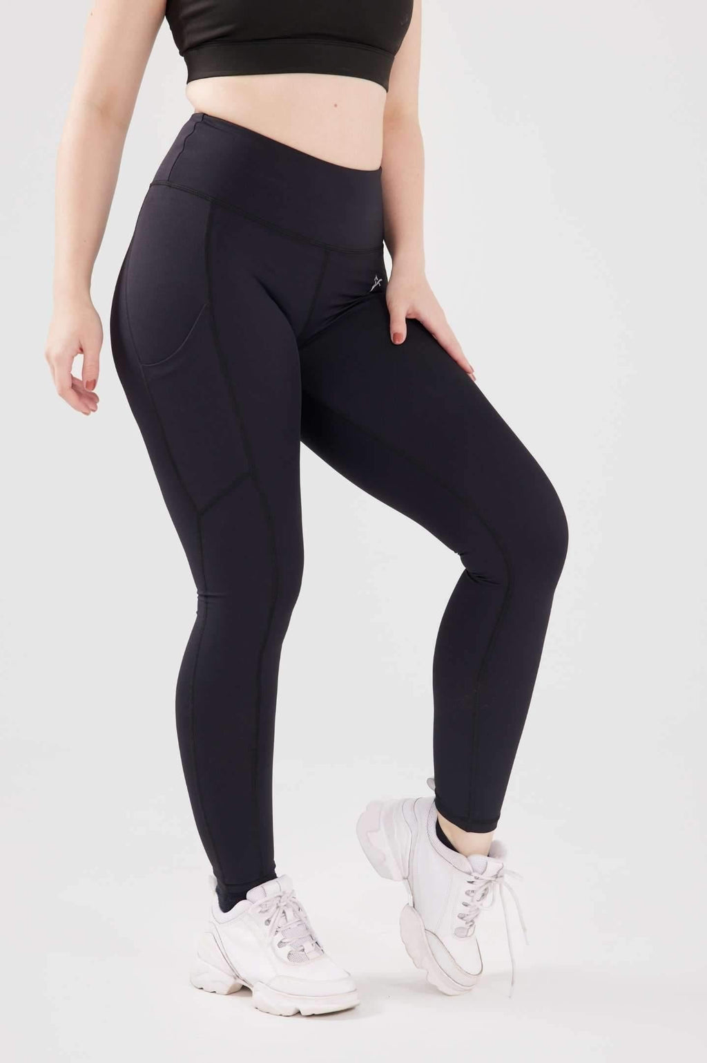 Close up girl posing hand on thigh wearing black luxe pocket leggings side