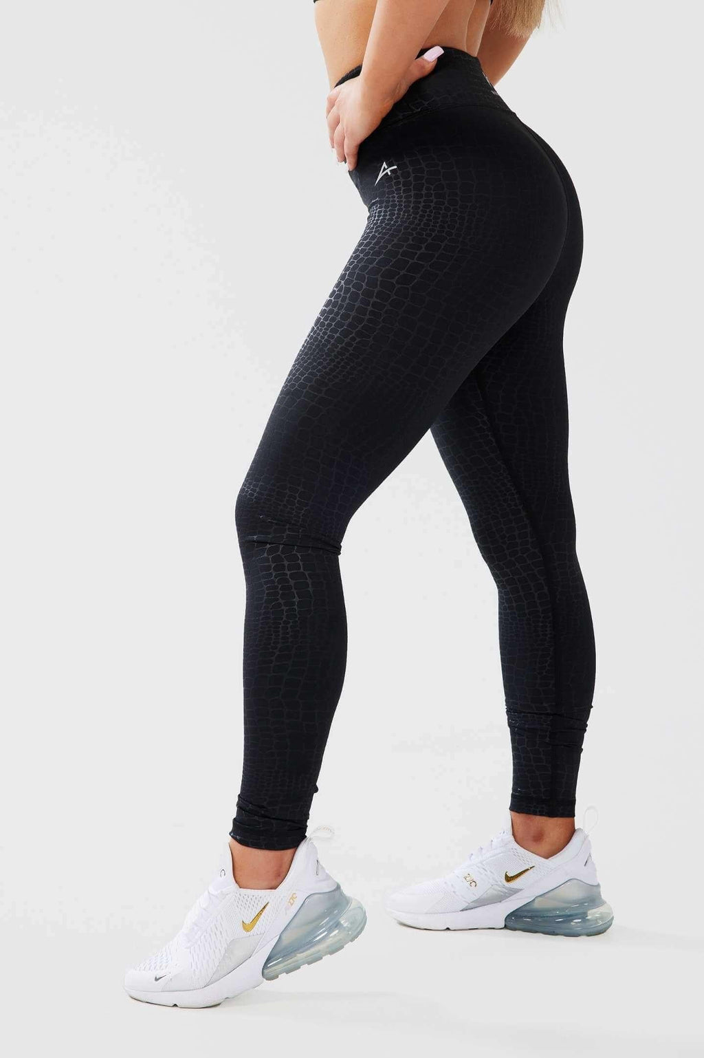 Girl posing hands on hip wearing luxe snake print leggings side shot